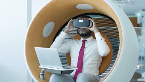 Businessman-using-laptop-and-vr-headset